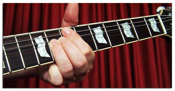 how to mute the sound of the guitar strings with the index finger